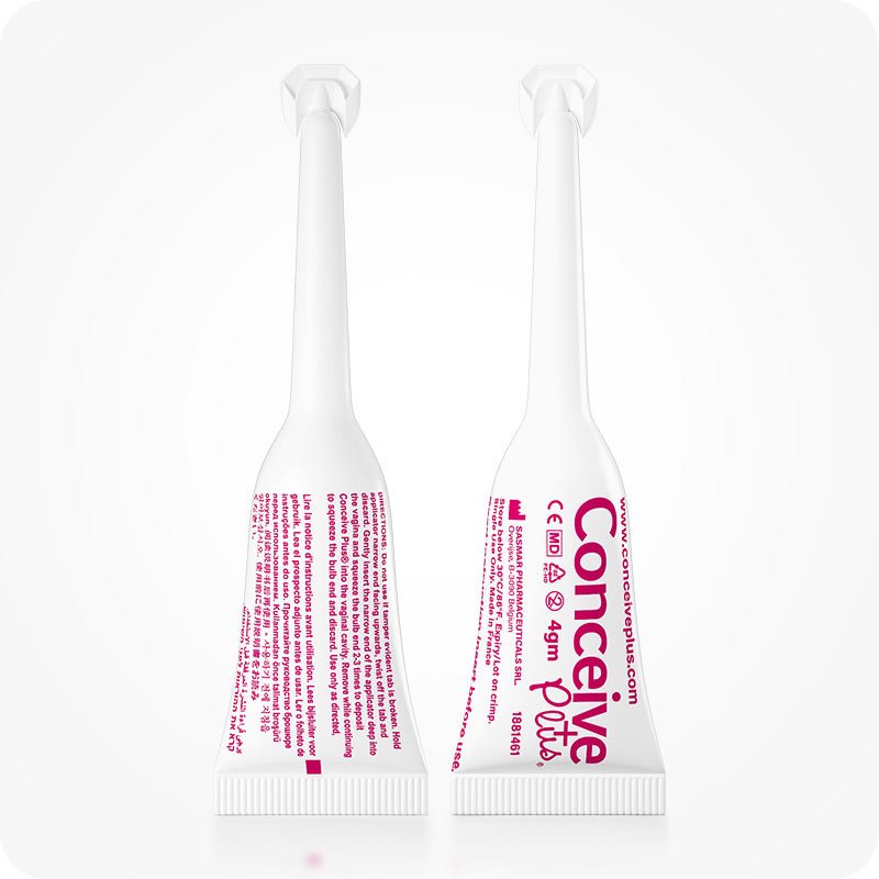 Image of two Conceive Plus try me size fertility lubricant applicators placed side by side on a white background. One applicator has its backside towards camera while the other one has its front side towards camera. White applicators pink branding and highlights info about manufacturer, website url, directions to apply, and quantity of the lube.